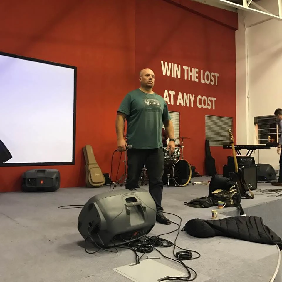 Lowell Jeffery teaching with a microphone on a church stage