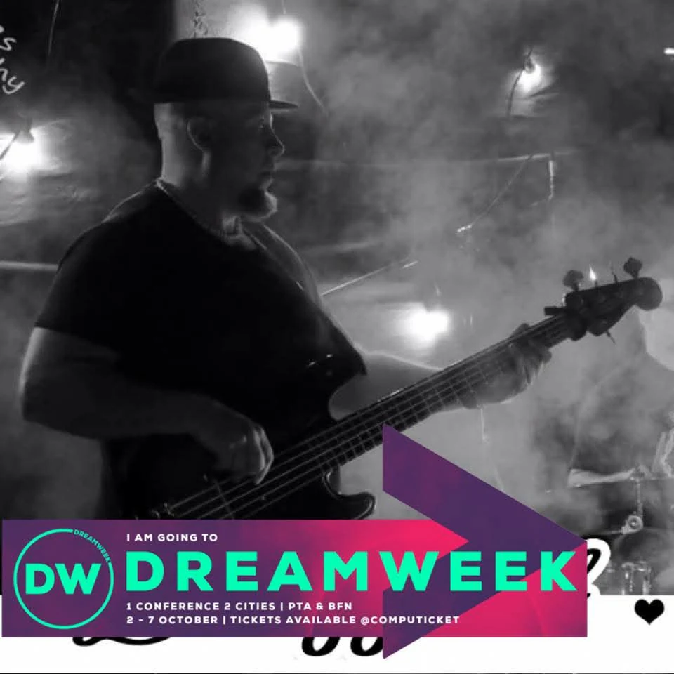 Lowell Jeffery playing bass guitar in a black-and-white DreamWeek performance photo