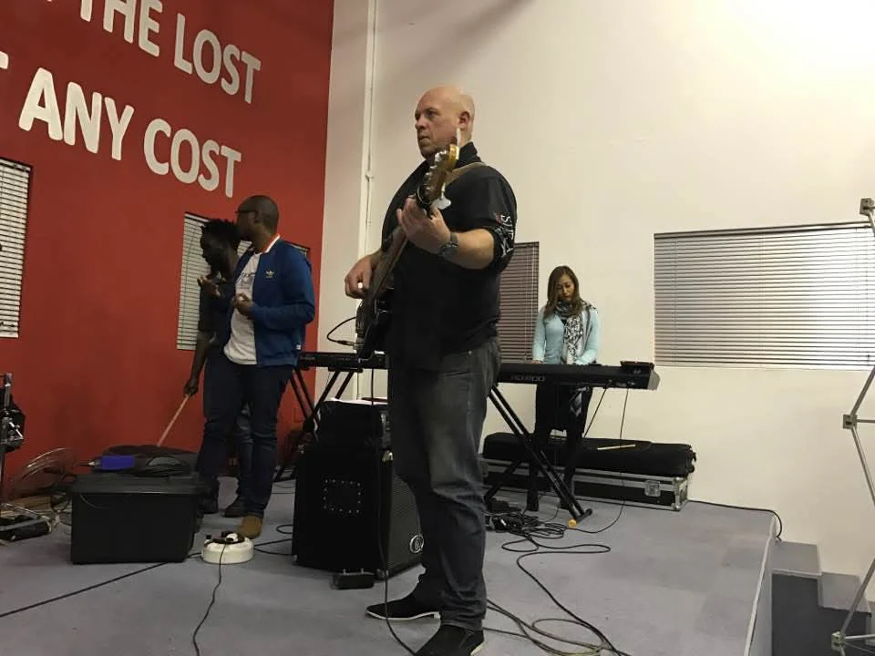 Lowell Jeffery playing bass with the worship band on a church stage